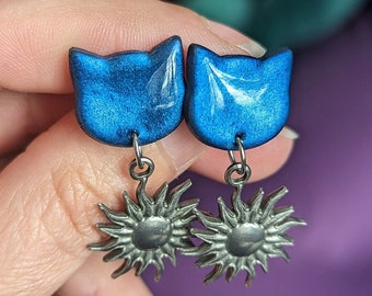 Blauwe kattenoorbellen met zilveren zon. Dieren sieraden. Roestvrij stalen chips.