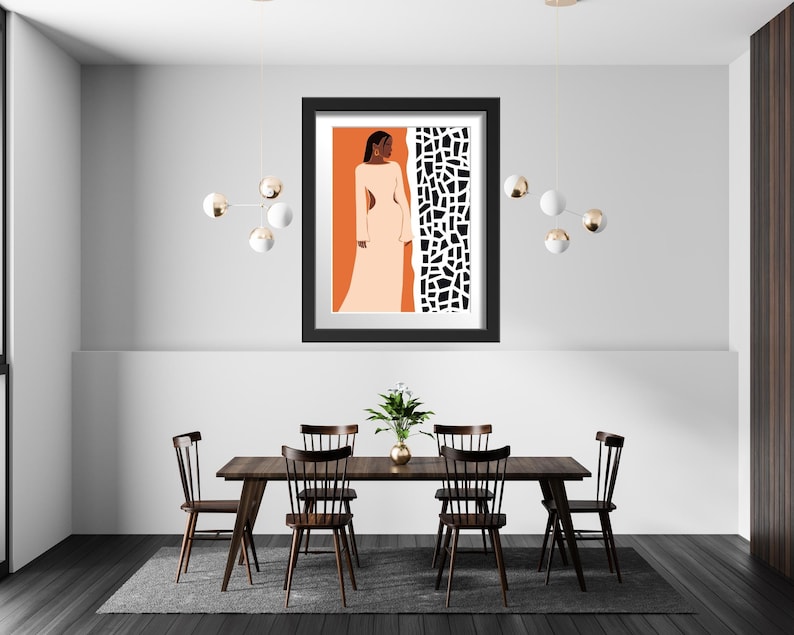 May include: A black framed print of a woman in a white dress standing in front of a black and white geometric pattern. The print is hanging on a white wall above a wooden dining table with four chairs.
