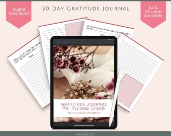 May include: A digital download of a 30-day gratitude journal with guided prompts. The journal cover features a floral arrangement with a vintage brooch on a white fabric background. The text "GRATITUDE JOURNAL For Personal Growth WITH GUIDED PROMPTS" is displayed on the cover.