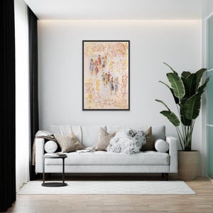 May include: A framed painting of a group of people in a white and yellow abstract background. The people are wearing colorful clothing and are standing in a circle. The painting is in a black frame and is hanging on a white wall.