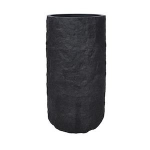 Könnte beinhalten: Ein hoher, zylindrischer schwarzer Pflanzkübel mit einer strukturierten, steinartigen Oberfläche. Der Pflanzkübel hat eine breite Öffnung oben und eine leicht abgerundete Basis. Die dunkle Farbe und die raue Textur verleihen ihm ein natürliches, rustikales Aussehen.