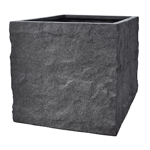 Könnte beinhalten: Ein quadratischer, dunkelgrauer Pflanzkübel mit einer strukturierten, steinartigen Oberfläche. Der Pflanzkübel hat eine raue, unebene Oberfläche und eine einfache, offene Oberseite. Ideal für den Außen- oder Innenbereich, er verleiht jedem Raum einen Hauch von natürlicher Eleganz.