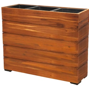 Może przedstawiać: Prostokątna drewniana donica o ciepłym brązowym wykończeniu. Donica zbudowana jest z poziomych drewnianych desek i posiada trzy czarne plastikowe wkładki na górze. Donica przeznaczona jest do użytku zewnętrznego.