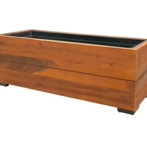 Peut inclure: Un bac à plantes rectangulaire en bois avec une finition en bois naturel. Le bac a un intérieur noir et repose sur de petits pieds noirs. Idéal pour les plantes d'intérieur ou d'extérieur.