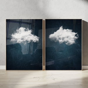 Könnte beinhalten: Zwei gerahmte Drucke mit einer weißen Wolke auf einem dunkelblauen Hintergrund. Die Wolke befindet sich in der Mitte jedes Drucks.