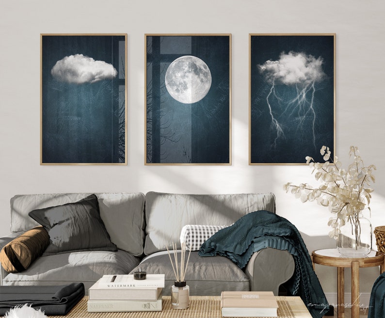 May include: Three framed prints with a dark blue background and white clouds. The center print features a full moon, while the left and right prints feature clouds with rain and lightning, respectively.