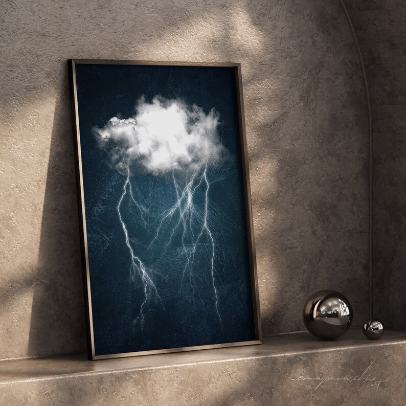 May include: A framed print of a white cloud with lightning bolts on a dark blue background.