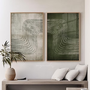 Puede incluir: Dos impresiones artísticas abstractas enmarcadas. Una impresión presenta un fondo beige con líneas curvas negras, la otra un fondo verde oscuro con líneas curvas blancas. Ambas están en marcos de madera marrón claro. La obra de arte se exhibe sobre un banco de madera.