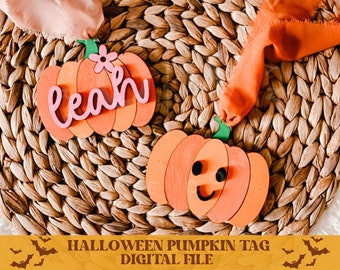 May include: Two wooden pumpkin shaped Halloween tags. One tag is orange with a happy face and the other is orange with the name "Leah" written in pink.