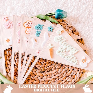 Pode incluir: Um conjunto de seis bandeiras de madeira em forma de flâmula em cores pastel com tema de Páscoa. As bandeiras apresentam silhuetas de coelhos, flores, cenouras e as palavras "Feliz Páscoa".