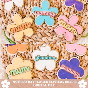 Puede incluir: Un conjunto de seis llaveros de madera con forma de flor en diferentes colores y con diferentes palabras. Las palabras en los llaveros son "mum", "mommy", "mom", "grandma" y "mommy".