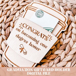 Pode incluir: Porta-cart&atilde;o de presente de madeira em forma de x&iacute;cara de caf&eacute; com o texto "CONGRATS on becoming one degree hotter" e um &iacute;cone de chap&eacute;u de formatura.