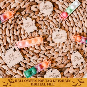 Op de afbeelding: Een set digitale bestanden voor printbare Halloween pop-tag sleutelhangers. De tags hebben verschillende ontwerpen, waaronder geesten, pompoenen en vleermuizen. De tags bevatten ook de tekst "Stay Spooky!" en "Happy Halloween!"