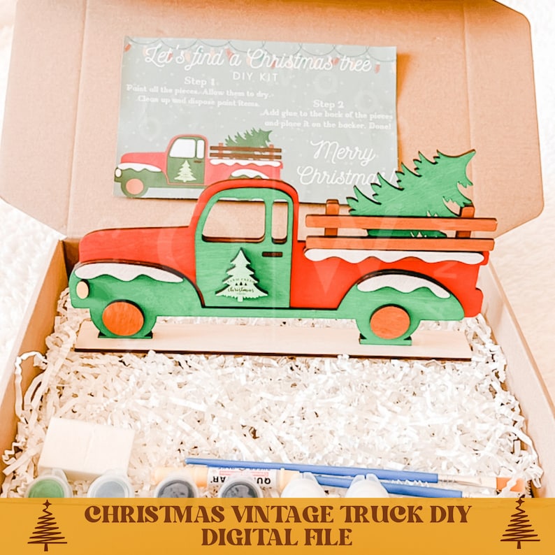 May include: A red vintage truck with a green Christmas tree in the bed. The truck is made of wood and is ready to be painted. The kit includes paint, brushes, and glue. "Let's find a Christmas tree DIY Kit" is written on the instructions card.