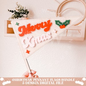 May include: A wooden pennant flag with the words "Merry Xmas" in red and pink letters. The flag is decorated with green holly leaves and red berries.