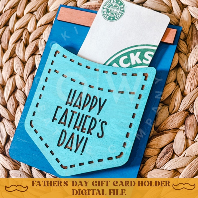 May include: A blue and turquoise wooden card holder with a pocket for a gift card. The holder has the text "Happy Father's Day!" on the front.