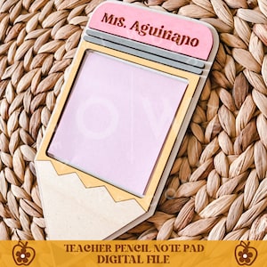 May include: A wooden pencil-shaped notepad with a pink note pad. The top of the pencil is pink with the name "Ms. Aguirano" engraved. The bottom of the notepad has the text "TEACHER PENCIL NOTE PAD DIGITAL FILE".