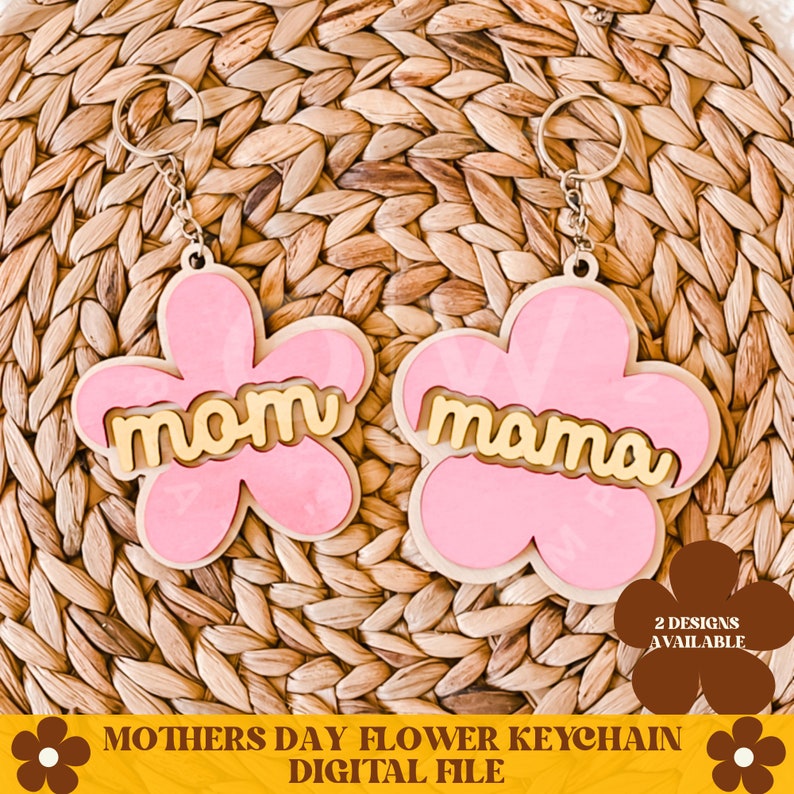 May include: Two pink flower-shaped keychains with gold lettering. One keychain says "mom" and the other says "mama".