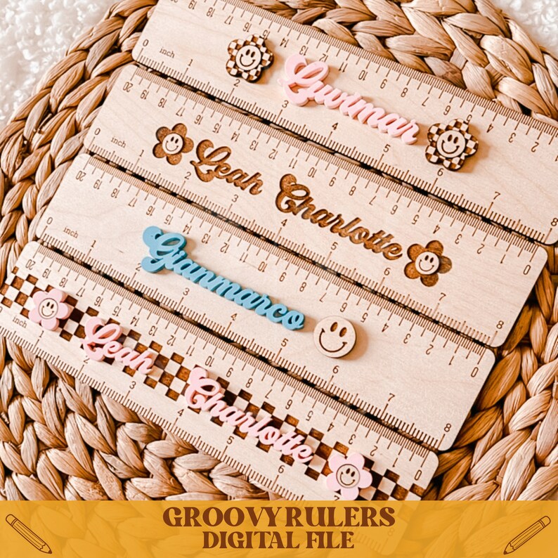 May include: Four wooden rulers with personalized names in a retro font, each with a smiley face and a different color. The names are Guimar, Leah Charlotte, Gianmarco, and Leah Charlotte. The rulers are 12 inches long.