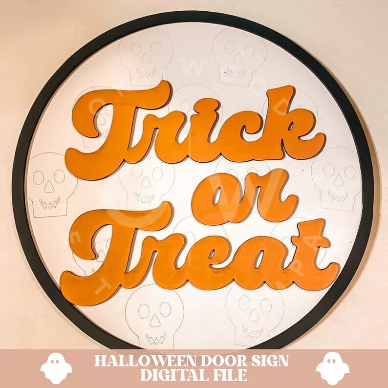 Pode incluir: Um sinal de porta redondo de madeira com moldura preta. O sinal diz "Trick or Treat" em letras laranja sobre fundo branco. O fundo &eacute; decorado com contornos de caveiras brancas.