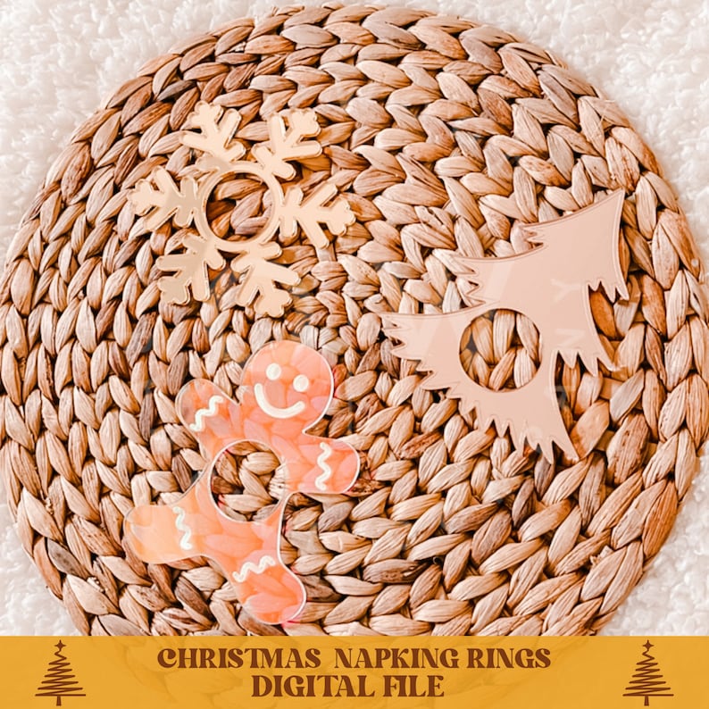 Puede incluir: Tres anillos para servilletas de Navidad, uno con forma de hombre de jengibre, otro con forma de copo de nieve y otro con forma de &aacute;rbol de Navidad. Los anillos est&aacute;n hechos de un material transparente con un aspecto esmerilado y est&aacute;n colocados sobre un mantel tejido.