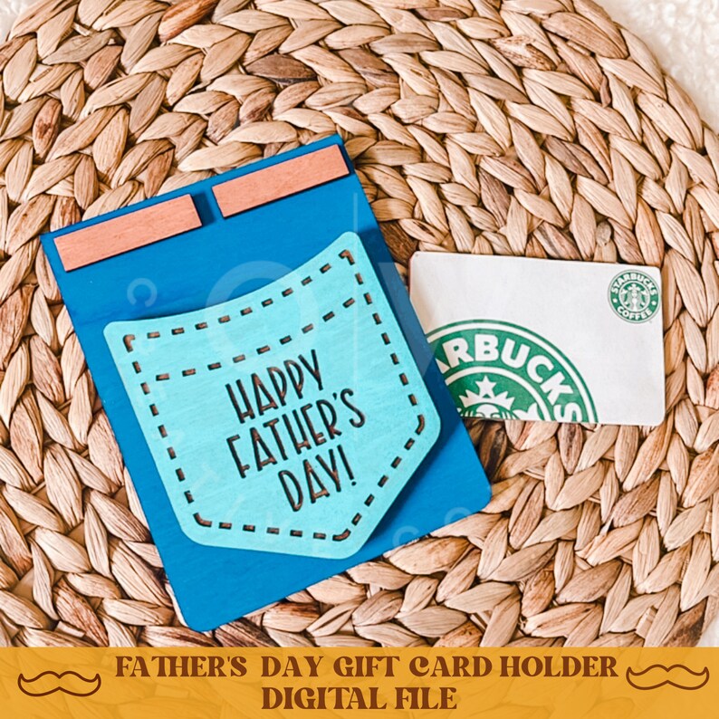 May include: Blue wooden card holder with a pocket cutout and the text "Happy Father's Day!" in a blue and white font. The card holder is designed to hold a gift card.