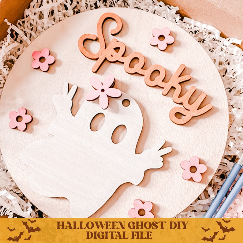May include: A wooden craft project featuring a ghost with pink flowers and the word "Spooky" in brown letters. This DIY Halloween ghost craft is a digital file.