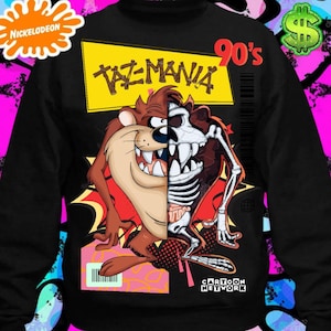 Peut inclure: Sweat-shirt noir avec une image de dessin animé de Taz de Taz-Mania. L'image montre Taz avec un squelette à l'intérieur de lui. Le texte "Taz-Mania 90's" est imprimé sur le sweat-shirt. Le logo Cartoon Network est également imprimé sur le sweat-shirt.