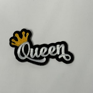 May include: Black and white embroidered patch with the word "Queen" in a cursive font. A gold crown is above the word.