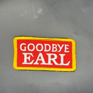 May include: A red and yellow embroidered patch with the text "Goodbye Earl" in white lettering.
