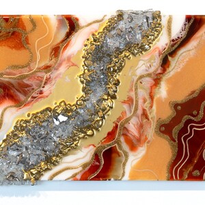 May include: Abstract art painting with a gold, white, and red color scheme. The painting features a textured, glittery surface with a central crack filled with silver and gold accents.