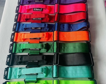 May include: A set of 12 colorful straps with black buckles and the text "EDG" printed on them. The straps are made of a woven fabric and have a loop on one end. The straps are arranged in a row from top to bottom, with the colors alternating.