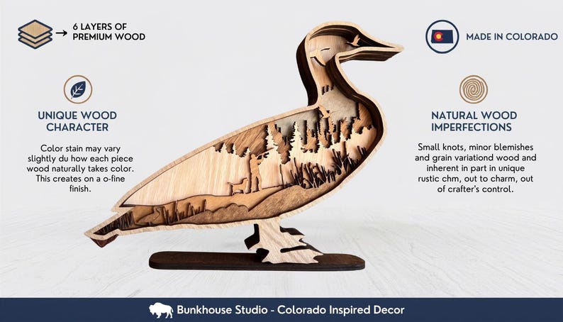 May include: A multi-layered wooden duck silhouette featuring a laser-cut landscape scene with a person and dog. Text includes 6 LAYERS OF PREMIUM WOOD, MADE IN COLORADO, UNIQUE WOOD CHARACTER, NATURAL WOOD IMPERFECTIONS, and Bunkhouse Studio - Colorado Inspired Decor.