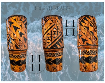 May include: Three wooden tumblers with intricate black and orange tribal designs. The tumblers feature geometric patterns and the text "HOLGATE KRAFTS". The background is a blue and white water pattern.
