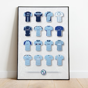May include: A poster showcasing 16 different football shirts, all in shades of blue and white. The shirts are arranged in a grid pattern, with the team logo visible on each shirt. The poster is framed in black and has a white background.