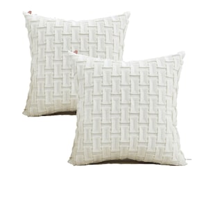 May include: Two off-white decorative throw pillows. Each square pillow features a woven, textured pattern. The pillows are placed on a white background. The pillows are approximately 18 inches square.