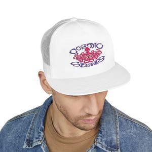 Könnte beinhalten: Weiße Trucker-Cap mit Mesh-Rückseite und flachem Schirm. Auf der Kappe steht der Text "Cosmic Squids" in Lila und Pink, mit einer stilisierten Tintenfisch-Grafik. Getragen von einer Person in einer Jeansjacke.