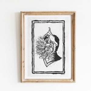 Puede incluir: Ilustraci&oacute;n en blanco y negro de una cabeza humana con un estallido de sol que emana de ella. La persona lleva un casco y tiene barba. La ilustraci&oacute;n est&aacute; enmarcada en un marco de madera.