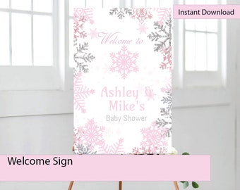 May include: A printable welcome sign for a baby shower with a winter theme. The sign features a white background with pink and silver snowflakes and the text "Welcome to Ashley & Mike's Baby Shower".