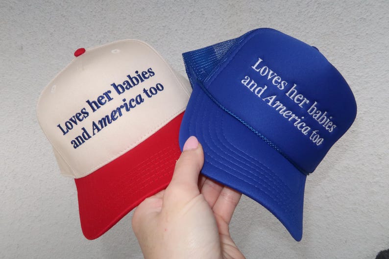 embroidered royal blue foam/ canvas cream and red hat that says Loves her babies and America too
