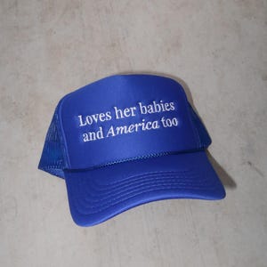embroidered royal blue foam hat that says Loves her babies and America too