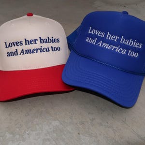 embroidered royal blue foam/ canvas cream and red hat that says Loves her babies and America too