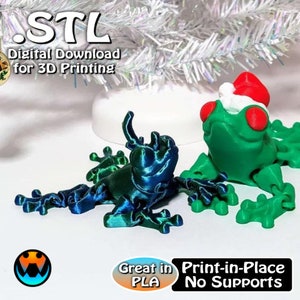 May include: Two 3D printed frogs, one green with a red Santa hat and the other blue and green. The text "STL Digital Download for 3D Printing" is at the top of the image. The text "Great in PLA Print-in-Place No Supports" is at the bottom of the image.