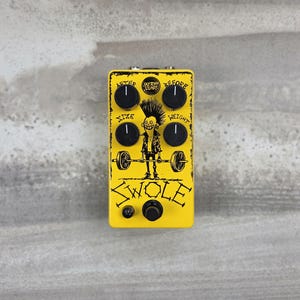 May include: A yellow guitar effects pedal with black knobs and a graphic of a cartoon character lifting a barbell. The text reads Sketchy Sounds, After, Before, Size, Weight, and Swole. It features four black control knobs and one small black switch.