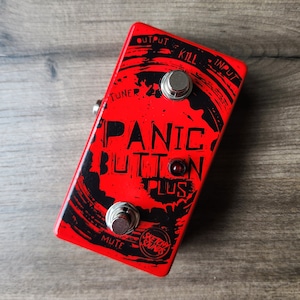 May include: Red guitar effects pedal with black text that reads "Panic Button Plus" and a black and white graphic design. The pedal has three knobs labeled "Kill", "Mute", and "Tuner".