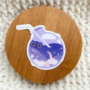 May include: A sticker of a glass bottle filled with a purple liquid, with a straw sticking out of the top. The liquid has a galaxy design with stars, a crescent moon, and clouds. A black cat face is peeking out from behind the liquid.