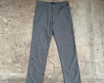 Könnte beinhalten: Graue Hose mit klassischem, geradem Bein. Die Hose hat einen Knopf- und Reißverschluss sowie Taschen. Der Stoff hat eine subtile Textur. Ein kleines blaues Etikett ist auf der Gesäßtasche sichtbar.