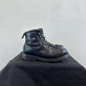 May include: Black leather lace-up boots with a chunky sole and silver eyelets.