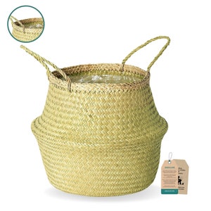 May include: A large, natural woven basket with two handles. The basket is made of light brown, natural material and has a slightly rounded shape. The basket is empty and ready to be filled with items.