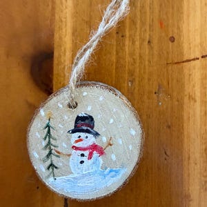 Tiny snowman ornament on wooden round